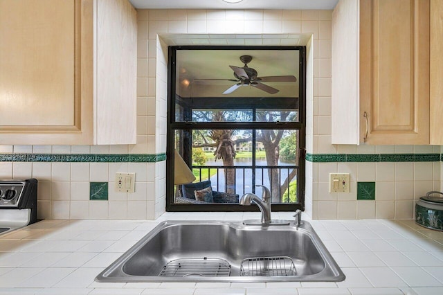 kitchen featuring tile counters, light brown cabinetry, sink, and ceiling fan