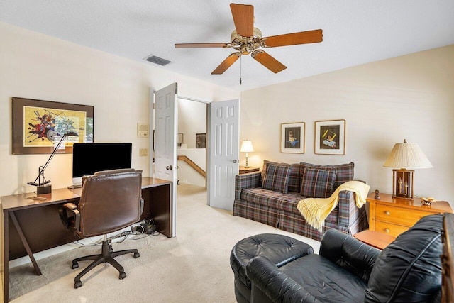 carpeted office with a textured ceiling and ceiling fan