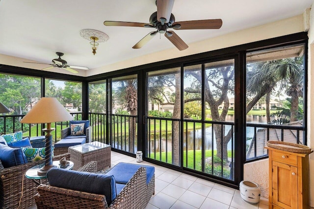 sunroom featuring a water view, ceiling fan, and plenty of natural light