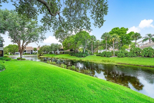 surrounding community featuring a water view and a lawn