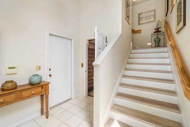 stairs featuring a high ceiling and tile patterned floors