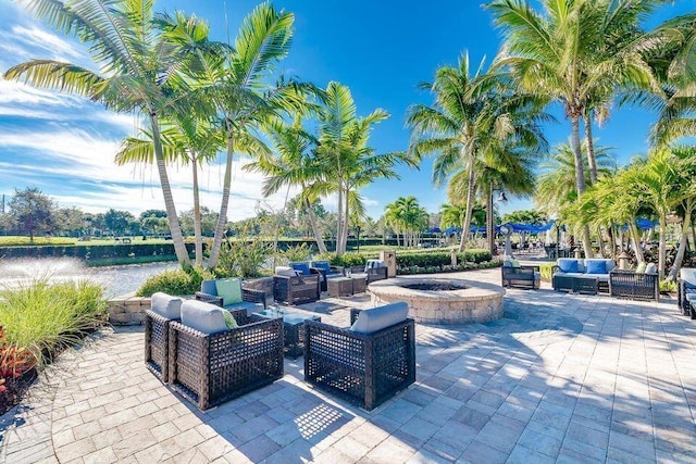 view of patio featuring an outdoor living space with a fire pit and a water view