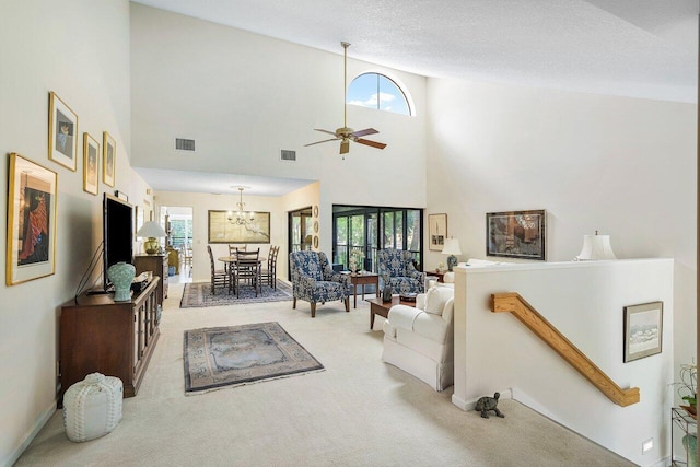 living room featuring a high ceiling, ceiling fan, carpet flooring, and a healthy amount of sunlight