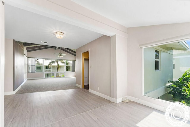 unfurnished living room with vaulted ceiling with beams, ceiling fan, and light carpet