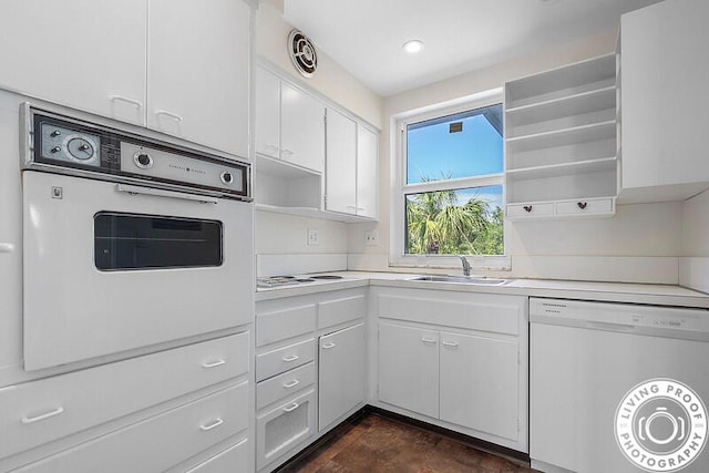 kitchen with white appliances, white cabinetry, and sink