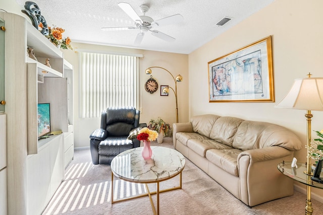 living room featuring carpet flooring, a textured ceiling, and ceiling fan