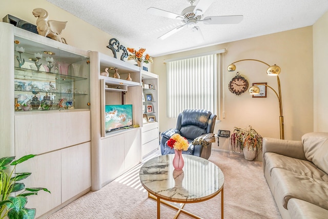 living room featuring a textured ceiling, carpet, and ceiling fan