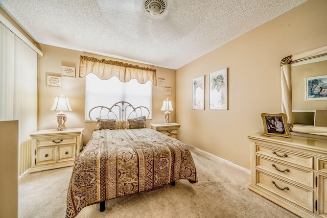 bedroom featuring a textured ceiling and light colored carpet