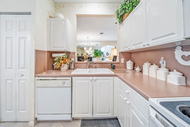 kitchen featuring white cabinets, dishwasher, light tile patterned floors, and sink