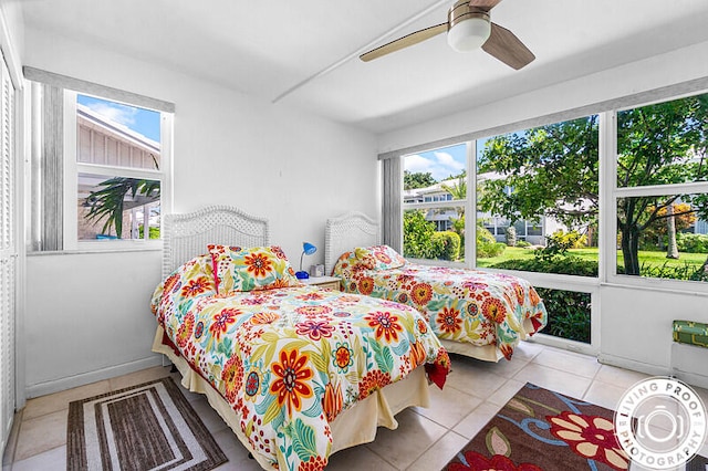 bedroom with ceiling fan, multiple windows, and light tile patterned flooring