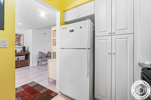 kitchen with white cabinets, light tile patterned floors, and white refrigerator