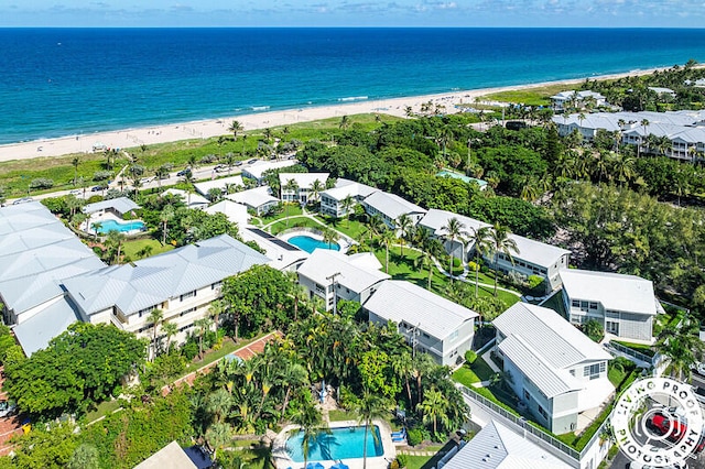 birds eye view of property featuring a water view and a beach view