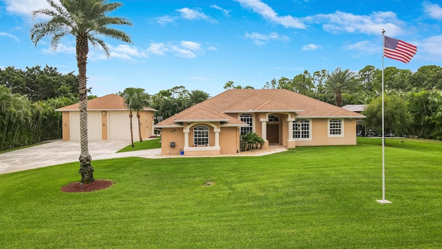 mediterranean / spanish home with a garage and a front lawn