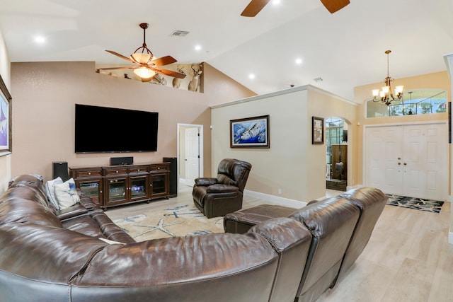 living room with ceiling fan with notable chandelier, hardwood / wood-style flooring, and high vaulted ceiling