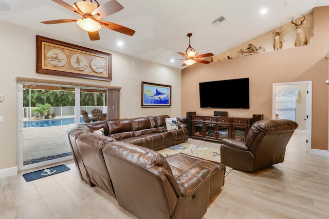 living room featuring light hardwood / wood-style flooring, high vaulted ceiling, and ceiling fan