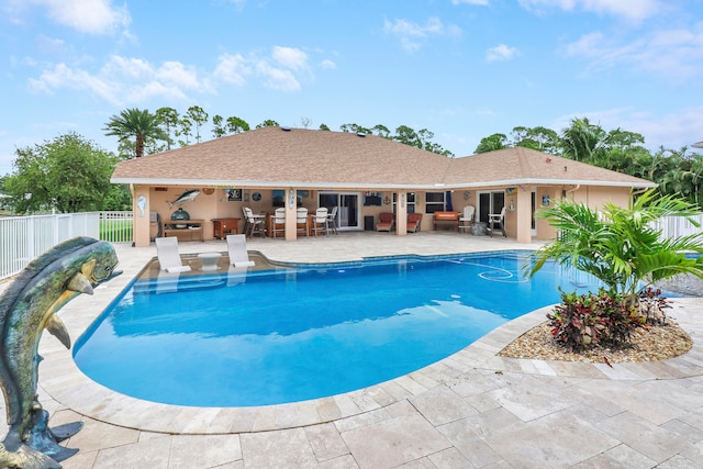 view of pool featuring exterior kitchen and a patio area