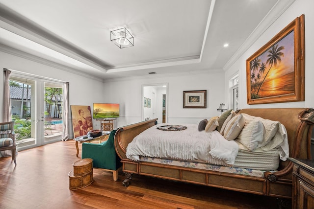 bedroom featuring access to outside, french doors, crown molding, a tray ceiling, and wood-type flooring