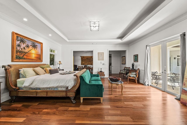 bedroom with french doors, access to outside, a raised ceiling, and hardwood / wood-style floors