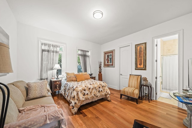 bedroom with hardwood / wood-style flooring and connected bathroom