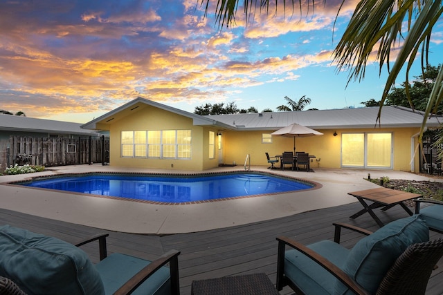 pool at dusk with a deck