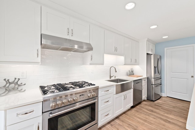 kitchen featuring tasteful backsplash, white cabinetry, sink, and appliances with stainless steel finishes