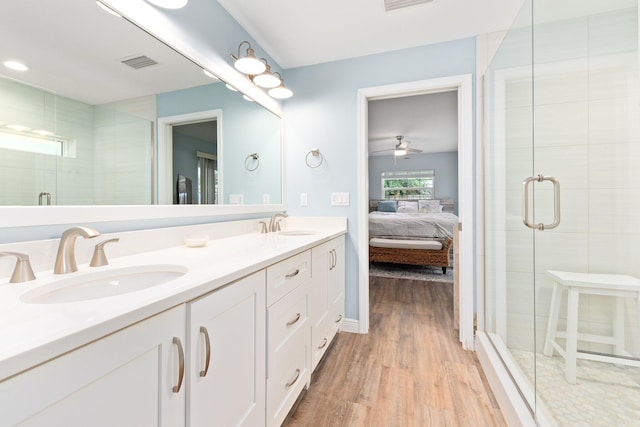 bathroom featuring hardwood / wood-style floors, ceiling fan, an enclosed shower, and vanity