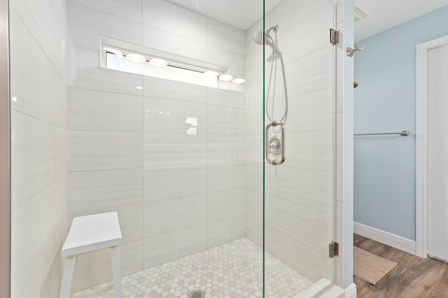 bathroom with wood-type flooring and an enclosed shower