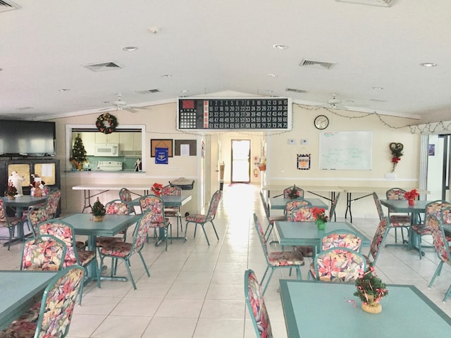 tiled dining space with plenty of natural light and vaulted ceiling