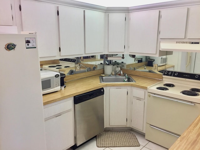 kitchen featuring light tile patterned flooring, sink, white cabinets, and white appliances