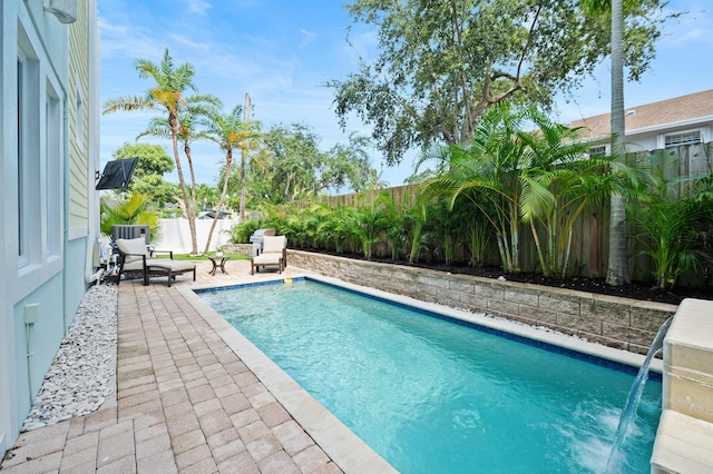 view of swimming pool with pool water feature and a patio area