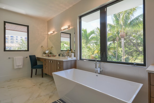 bathroom featuring tile patterned flooring, a bathing tub, and vanity