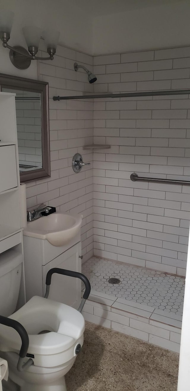 bathroom with a stall shower, tile walls, toilet, and vanity