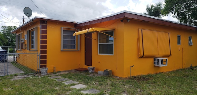 view of side of property featuring stucco siding and fence