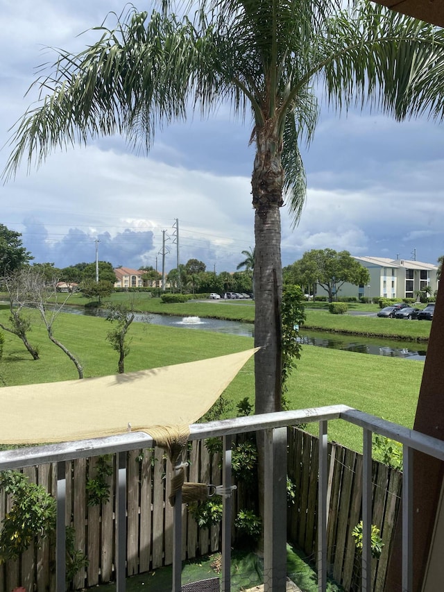 view of community with a lawn and a water view