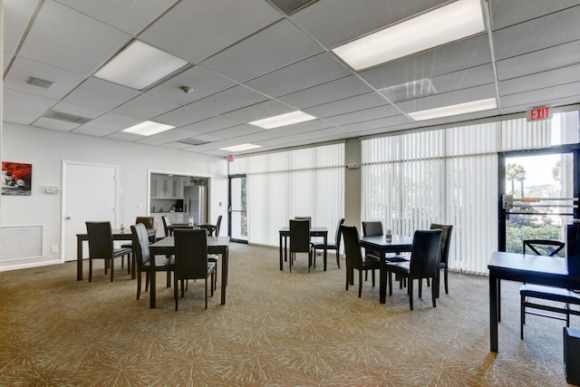 dining space with carpet and a paneled ceiling