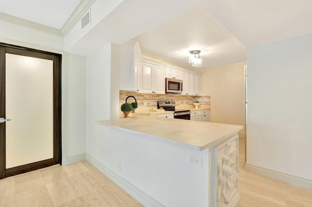 kitchen with kitchen peninsula, white cabinets, backsplash, stainless steel appliances, and sink