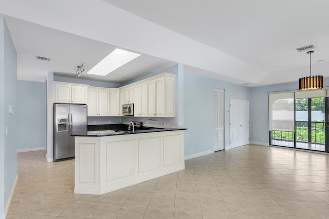 kitchen featuring a skylight, light tile patterned floors, stainless steel appliances, kitchen peninsula, and hanging light fixtures