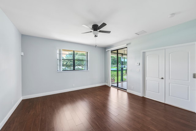 spare room with dark wood-type flooring and ceiling fan