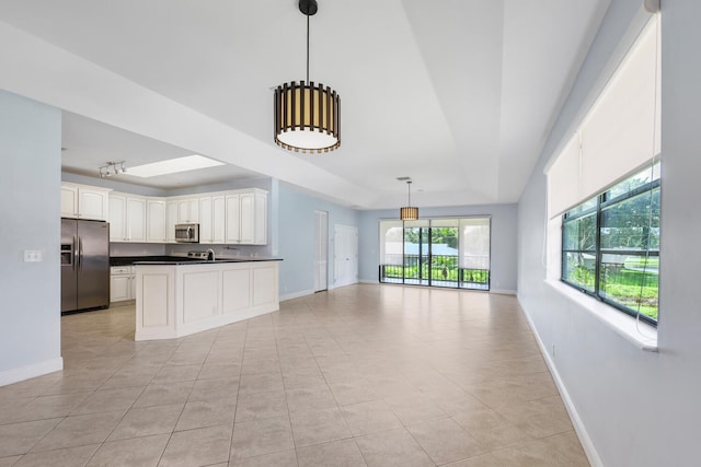 kitchen with white cabinetry, decorative light fixtures, stainless steel appliances, and light tile patterned flooring