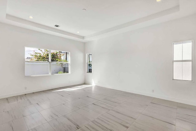 unfurnished room featuring a tray ceiling