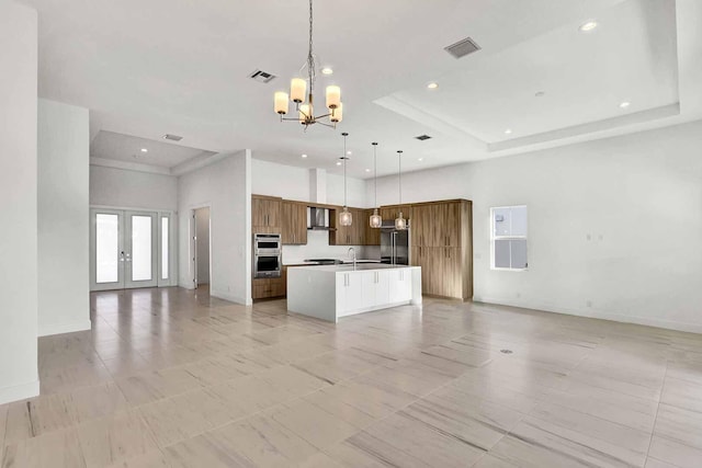 kitchen featuring hanging light fixtures, a center island, high end refrigerator, french doors, and a chandelier