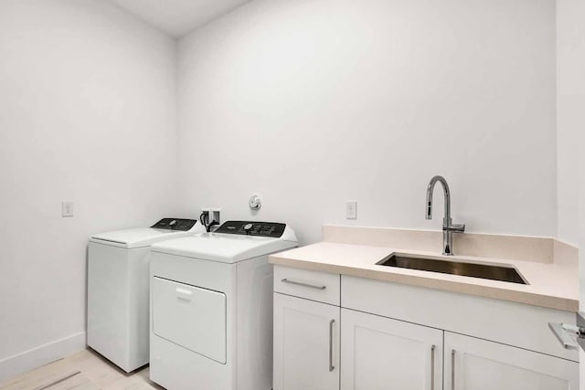 laundry area featuring cabinets, independent washer and dryer, and sink