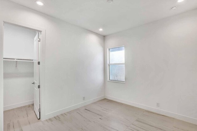 unfurnished bedroom with a spacious closet and a closet