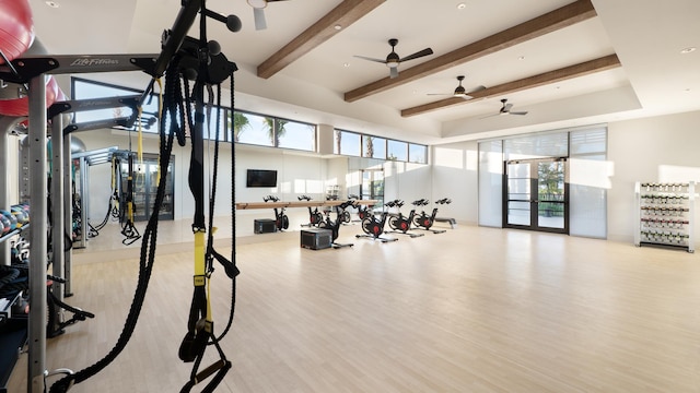 exercise room featuring a towering ceiling and light hardwood / wood-style flooring