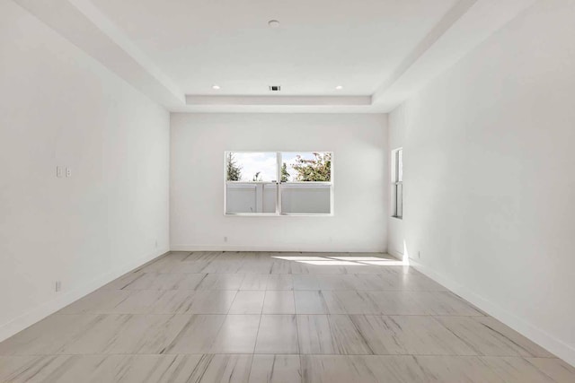 unfurnished room featuring a raised ceiling