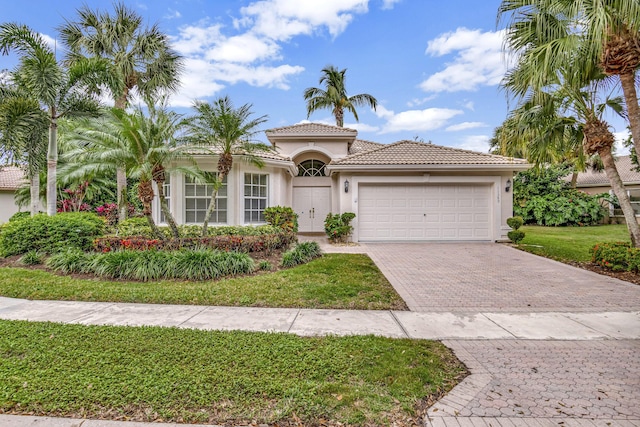 mediterranean / spanish house featuring a front yard and a garage