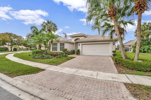 mediterranean / spanish house with a front lawn and a garage