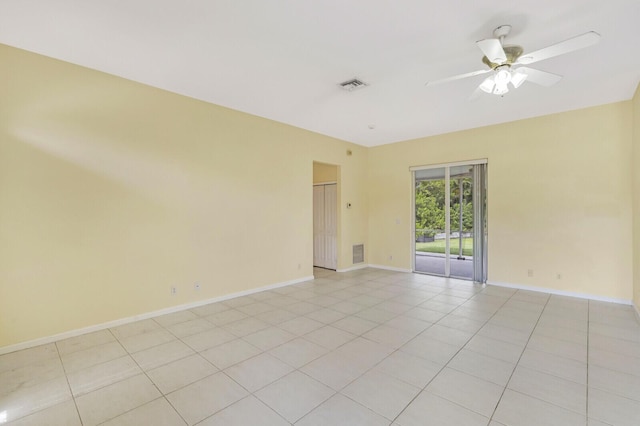 tiled spare room featuring ceiling fan