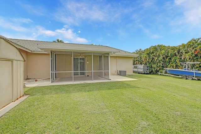 rear view of house featuring a patio area, central AC unit, a lawn, and a sunroom