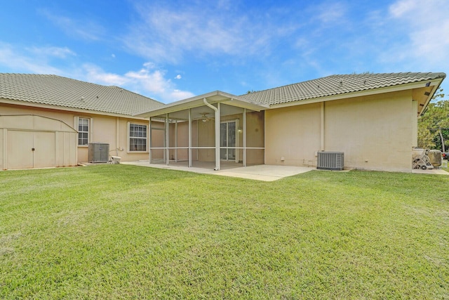 back of house with central AC unit, a patio area, and a yard